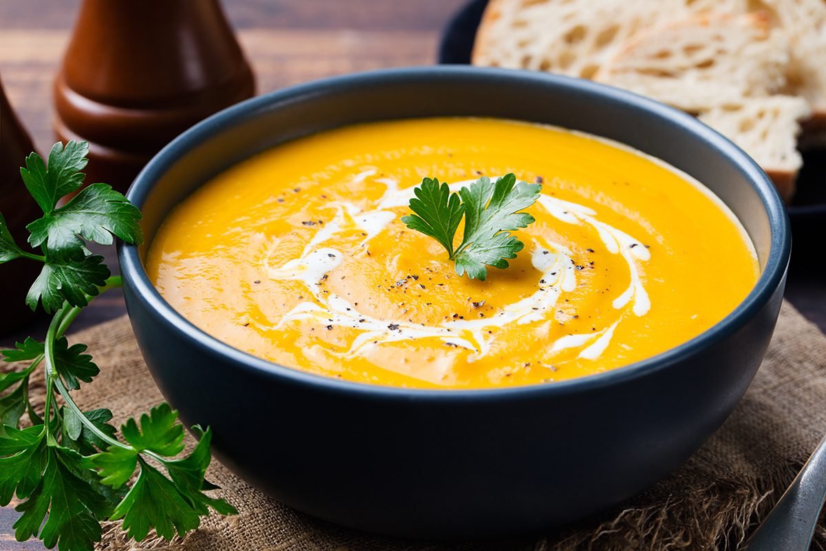 Pumpkin,And,Carrot,Soup,With,Cream,And,Parsley,On,Dark Pumpkin and carrot soup with cream and parsley on dark wooden background